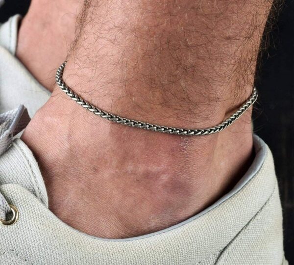 La chaîne de cheville pour homme est en acier inoxydable argenté avec un design torsadé. L’acier inoxydable est un matériau durable et résistant à la rouille, ce qui en fait un choix idéal pour les bijoux qui sont souvent exposés à l’eau ou à la sueur. La finition argentée ajoute une touche d’élégance et de sophistication. Le design torsadé de la chaîne est unique et attrayant. Les maillons de la chaîne sont torsadés, ce qui donne à la chaîne une texture et une apparence distinctes. Cela ajoute également une dimension supplémentaire à la chaîne, la rendant plus intéressante et visuellement attrayante. Cette chaîne de cheville peut être portée aussi bien pour des occasions décontractées que formelles. Elle peut ajouter une touche d’élégance à une tenue décontractée ou compléter un look formel.