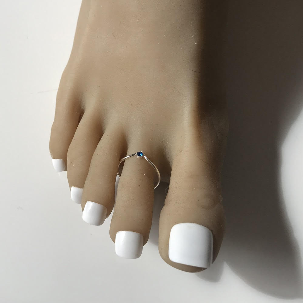 Cette bague de pied en argent 925 est un bijou élégant et raffiné qui ajoutera une touche de glamour à votre look estival. Dotée d'une pierre bleue en cristal de Swarovski, cette bague est à la fois discrète et captivante. Fabriquée avec soin, elle est conçue pour s'adapter confortablement à votre orteil, mettant en valeur sa beauté naturelle. Que vous soyez à la plage, en vacances ou simplement en train de vous détendre, cette bague de pied apportera une touche de sophistication à votre style. Son design intemporel en fait un accessoire polyvalent qui peut être porté avec n'importe quelle tenue, que ce soit une robe d'été légère ou un jean décontracté. Offrez-vous cette bague de pied argentée avec une pierre bleue éblouissante et ajoutez une touche de glamour à vos pieds. Les cristaux de Swarovski sont reconnus pour leur brillance supérieure et l'innovation de la coupe de leur facettes qui donnent des reflets exceptionnels.